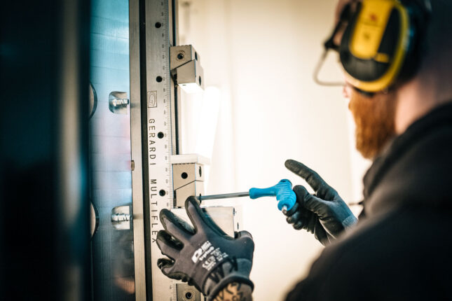Operat&ouml;r justerar verktyg i CNC-maskin vid bearbetning av aluminium.